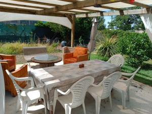 a wooden table and chairs under a pergola at Chambre chez l'habitant in Pierrelatte