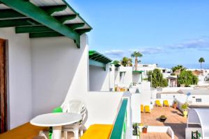 uma vista para a varanda de um hotel com uma mesa e cadeiras em Apartamentos Isabel em Puerto del Carmen