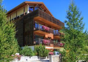 - un grand bâtiment avec des fleurs sur les balcons dans l'établissement Apart Lischana, à Samnaun