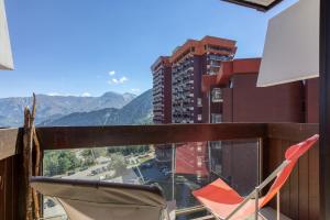 a chair on a balcony with a view of a building at Oiseau de Feu in Villarembert