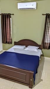 a bed with blue sheets and pillows in a bedroom at Shangri-laa hotel apartments in Tāzhekkod