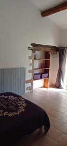 a bedroom with a bed and a stone wall at Le Petit Moulin Tournesol BnB in Sainte-Soline