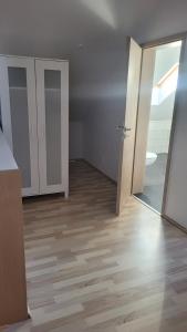 an empty room with a wooden floor and an open door at Schöne Maisonette Düren in Düren - Eifel
