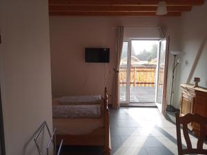 a room with two beds and a sliding glass door at Sonnenhof in Weilmünster