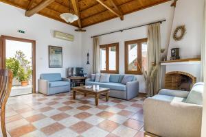a living room with couches and a fireplace at Villa Chrysalis in Skopelos Town