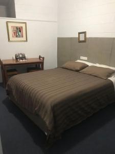 a bedroom with a large bed with a table at The Flinders Hotel Motel Port Augusta in Port Augusta