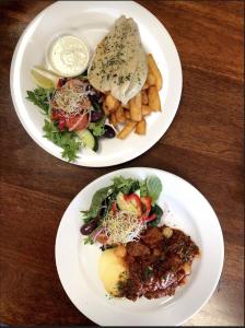 dos platos de comida en una mesa de madera en The Flinders Hotel Motel Port Augusta, en Port Augusta