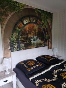 a bedroom with a painting of a waterfall at Ferienwohnung Schlaubetal Müllrose 1 in Müllrose