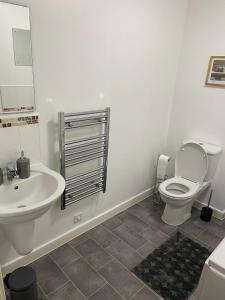 a white bathroom with a toilet and a sink at Remarkable 2-Bed Apartment in Wolverhampton in Wolverhampton