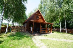 una pequeña cabaña en un patio con una valla en Siedlisko Czarny Bocian en Giby