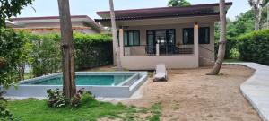 a house with a swimming pool in the yard at Samutra Residences in Thongsala