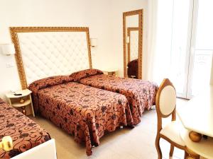 ベッラーリア・イジェア・マリーナにあるHotel Rosa Maria Eliteのベッド2台とテーブルが備わるホテルルームです。