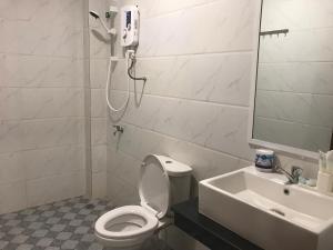 a bathroom with a toilet and a sink and a shower at LK Apartment & Hotel in Sihanoukville