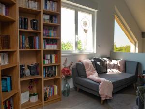 un soggiorno con divano e libreria di Home By Sab 