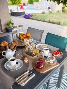 - une table avec des aliments pour le petit-déjeuner et du café dans l'établissement Home By Sab, 