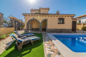 a villa with a swimming pool and two lounge chairs at Villa Paradise in Benalmádena