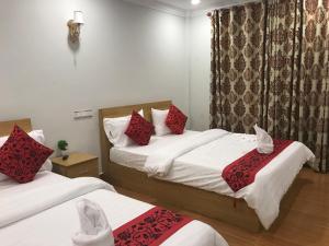 a hotel room with two beds and a window at LK Apartment & Hotel in Sihanoukville