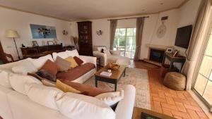 una sala de estar con un sofá blanco y un gato sobre una mesa en Peaceful 4BR villa on Gramacho golf resort w/ private pool, en Lagoa