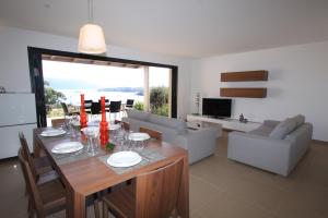 a dining room and living room with a table and chairs at Résidence Affasciata in Porto-Vecchio
