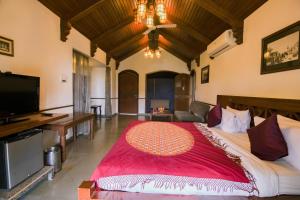 a bedroom with a large bed and a flat screen tv at Heritage Khirasara Palace in Rajkot