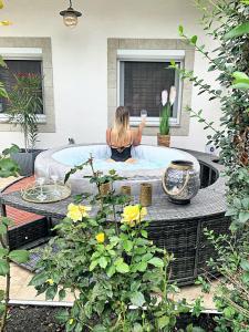 a woman sitting in a bath tub in a backyard at Gallér Jakuzzis Vendégház in Gárdony