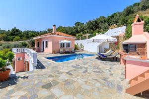 a villa with a swimming pool and a house at Villa Chrysalis in Skopelos Town