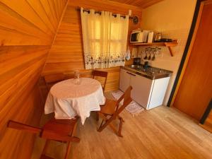 a small kitchen with a table and chairs in a room at Pousada Sítio Elias - Chalé 1 in Lauro Müller +9 photos