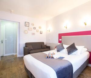 een hotelkamer met een groot bed en een stoel bij HOTEL DE PARIS MONTPARNASSE in Parijs