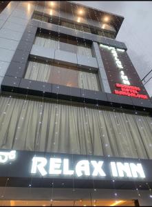 um edifício alto com um sinal de relaxamento em Relax Inn em Bangalore