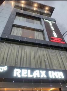 a tall building with a relax inc sign on it at Relax Inn in Bangalore