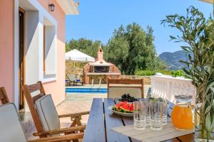 a wooden table with a bowl of fruit on a patio at Villa Chrysalis in Skopelos Town