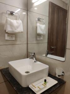 a bathroom with a white sink and a mirror at Relax Inn in Bangalore