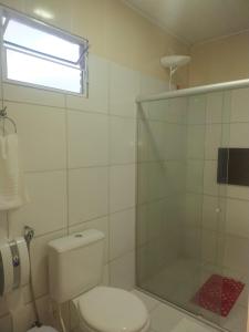 ein Badezimmer mit Toilette und Glasdusche in der Unterkunft Estalagem Vovô Elias in São Miguel dos Milagres