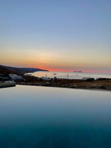 una gran masa de agua con la puesta de sol en el fondo en M-Vibes Mykonos Suites en Kalafatis