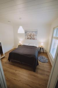 a bedroom with a large bed and two tables at Villa Dyyni Yyteri in Pori