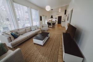 a living room with a couch and a flat screen tv at Villa Dyyni Yyteri - Sauna & Hot Tub - Near Beach in Pori