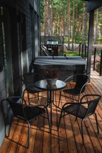 una veranda riparata con tavolo, sedie e pianoforte di Villa Dyyni Yyteri a Pori