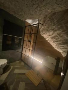bagno con lavandino e servizi igienici in una grotta di Casa Rural Bajo la Alcazaba a Setenil