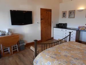 sypialnia z łóżkiem i telewizorem na ścianie w obiekcie Callwood Farm Annex Guest Room w mieście Belper