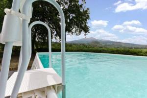 - une piscine avec une chaise blanche à côté dans l'établissement Case Vacanze Dietroserra, à Viagrande
