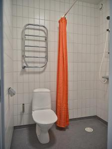 a bathroom with a toilet and an orange shower curtain at Herrestad Bed & Guestroom in Värnamo