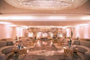 a lobby with couches and tables and a chandelier at Four Seasons Hotel Riyadh in Riyadh
