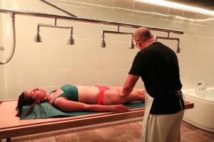 a man standing next to a woman laying on a bed in a bathroom at Pension Campello The Blue Med in Alicante