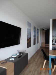 uma sala de estar com uma televisão de ecrã plano na parede em Apartament na Piaskowej em Żarnowska
