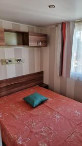 - une chambre dotée d'un lit rouge avec un oreiller vert dans l'établissement Camping Oasis Village, à Puget-sur Argens