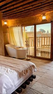 ein Schlafzimmer mit einer Badewanne und einem großen Fenster in der Unterkunft نزل حارة المسفاة Harit AL Misfah Inn in Misfāh