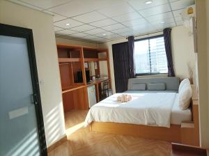 1 dormitorio con cama blanca y ventana en Double D Rooms & Cafe, en Bangkok