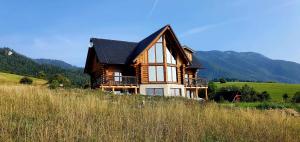 a wooden house sitting on top of a hill at Chalet Liptov in Ižipovce