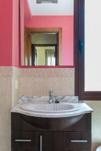 y baño con lavabo y espejo. en Casa Rural Sierramagna de 2 Dormitorios, en El Ronquillo