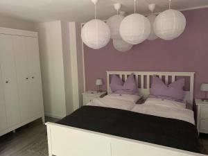 ein Schlafzimmer mit lila Wänden und ein Bett mit lila Kissen in der Unterkunft Ferienwohnung an der Oker in Altenau